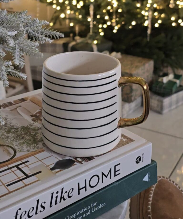 coffee mug set up on books near a Christmas tree