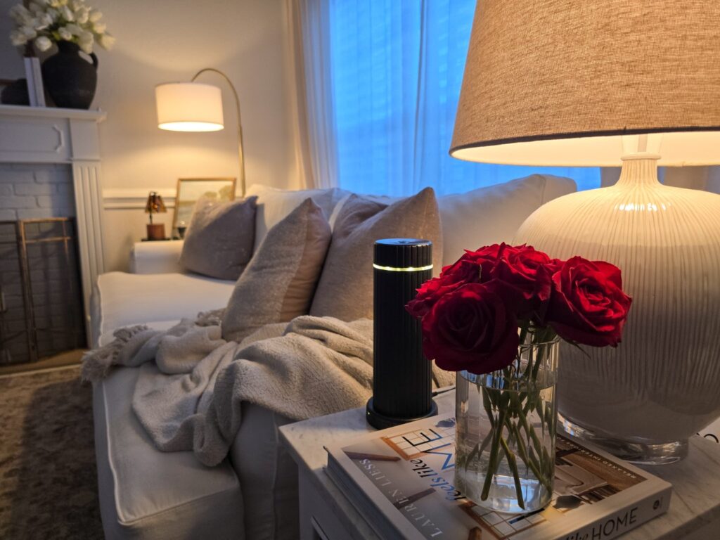 Warm living room transitioning from summer to fall with red roses, layered textiles and soft lamplight
