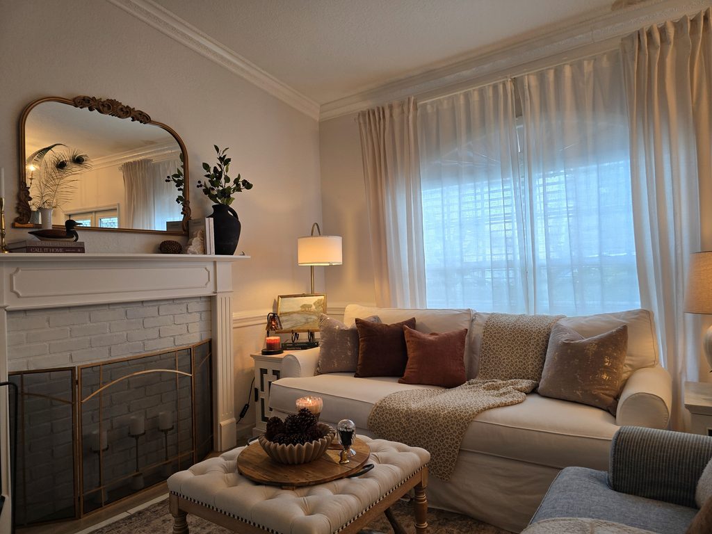 Living room with white sofa, and warm lamps glowing in the early evening.