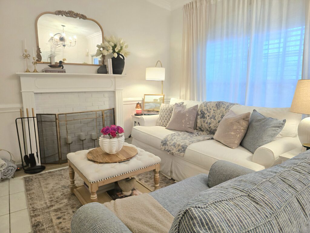 Builder-grade living room made to look custom with layered curtains, warm lighting, and timeless decor.