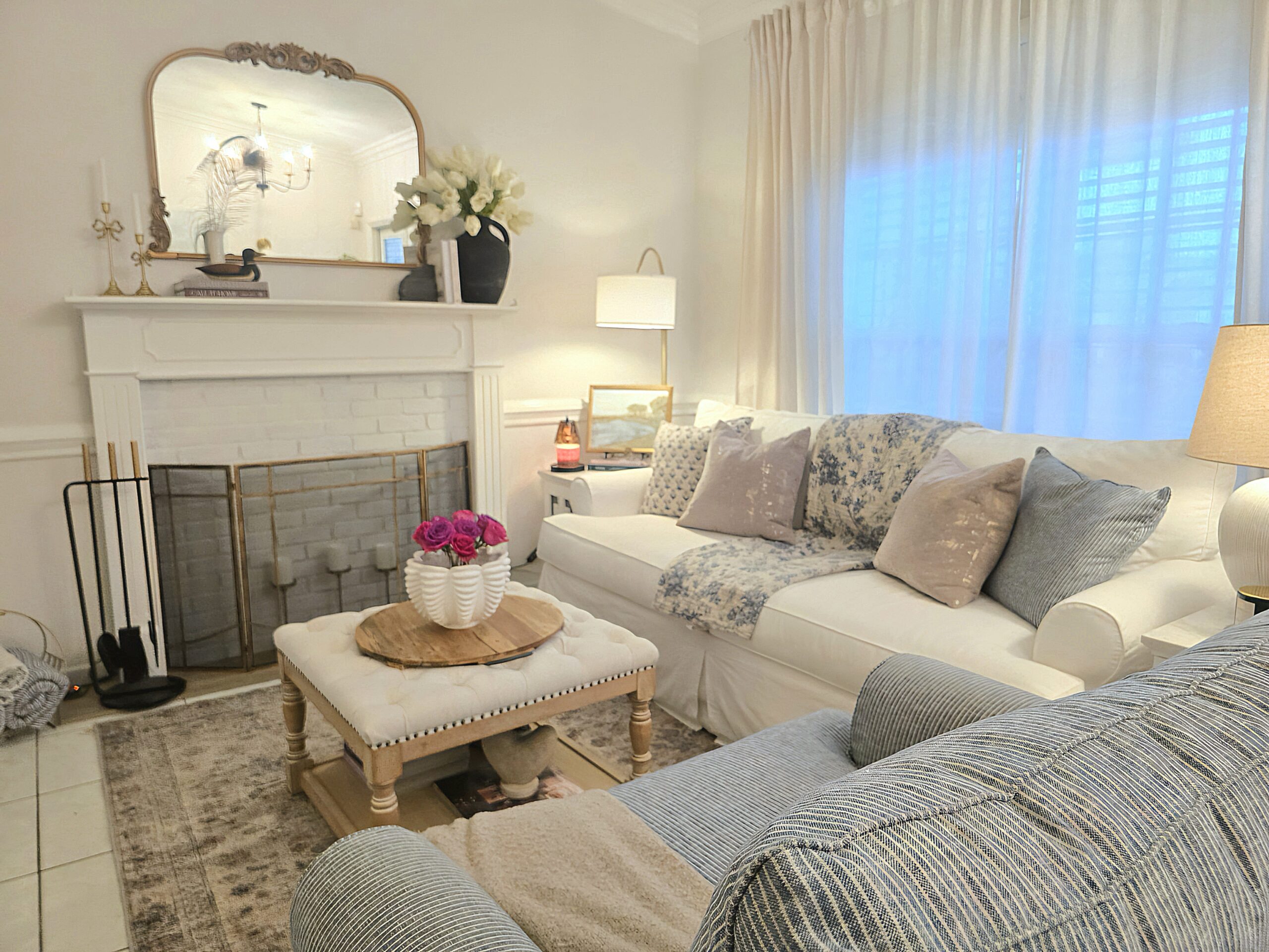 Builder-grade living room made to look custom with layered curtains, warm lighting, and timeless decor.