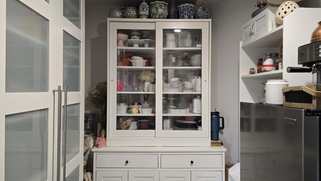 Butler's pantry with visible glass-front storage cabinet used for dishes and decorative pieces.