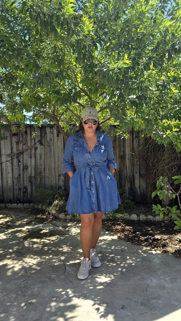 Denim dress styled with sneakers and sunglasses for a warm fall day in Miami.