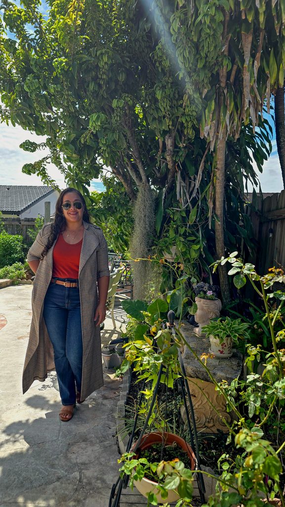 Jeans and rust tank top layered with a long trench coat for warm-weather fall style in Miami.