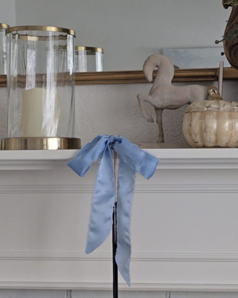 Wide soft blue ribbon bow with long floppy tails styled as a Christmas decoration